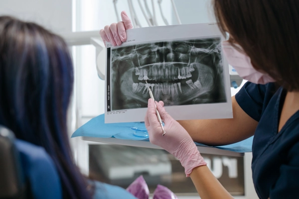 Dentista mostrando al paciente el estado de sus dientes